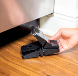 Reusable black rat snap trap with a strong snap and interlocking teeth for rodent control placed under the bed.